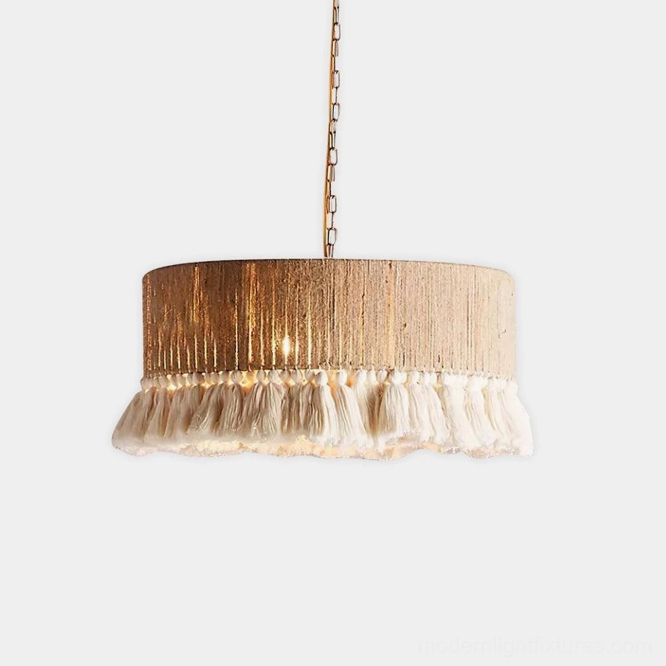 Large handwoven drum boho pendant lamp with thick off-white tassel trim, close-up glow