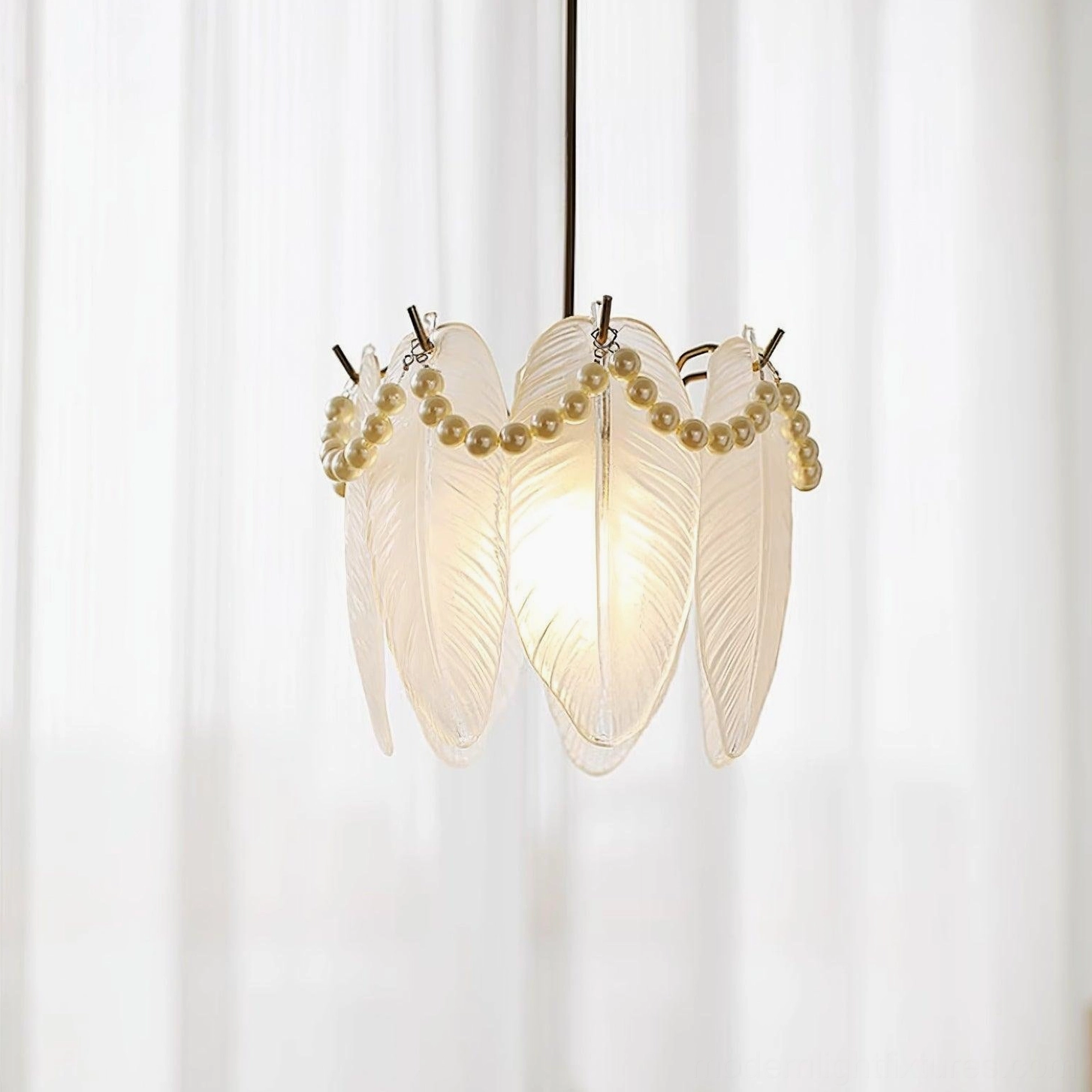 Large crystal feather glass petal pendant fixture with golden suspension hardware and sheer studio backdrop