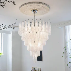 Large layered glass droplet chandelier installed in bright residential entryway with polished silver finish