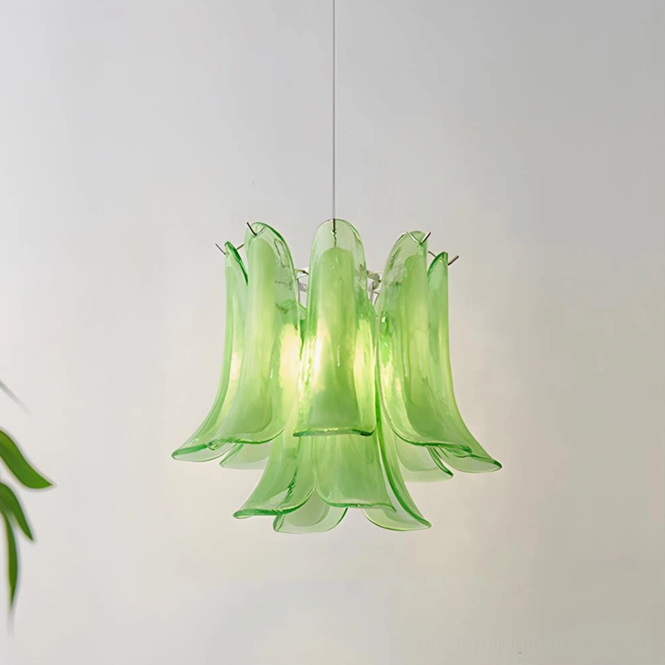 Large green glass petal pendant light suspended over dining furniture