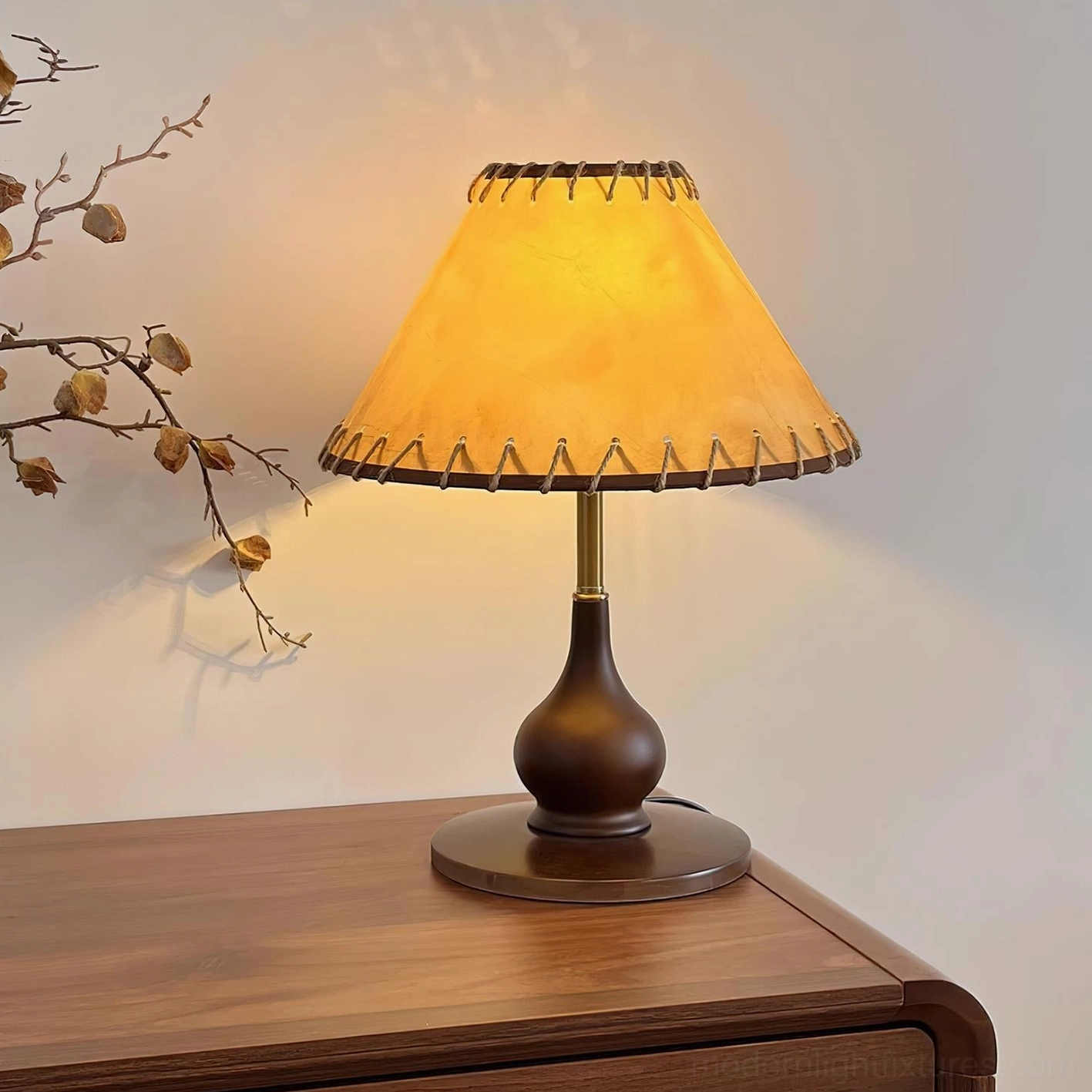 Lariat table lamp glowing warmly beside rustic home decor and natural branch styling