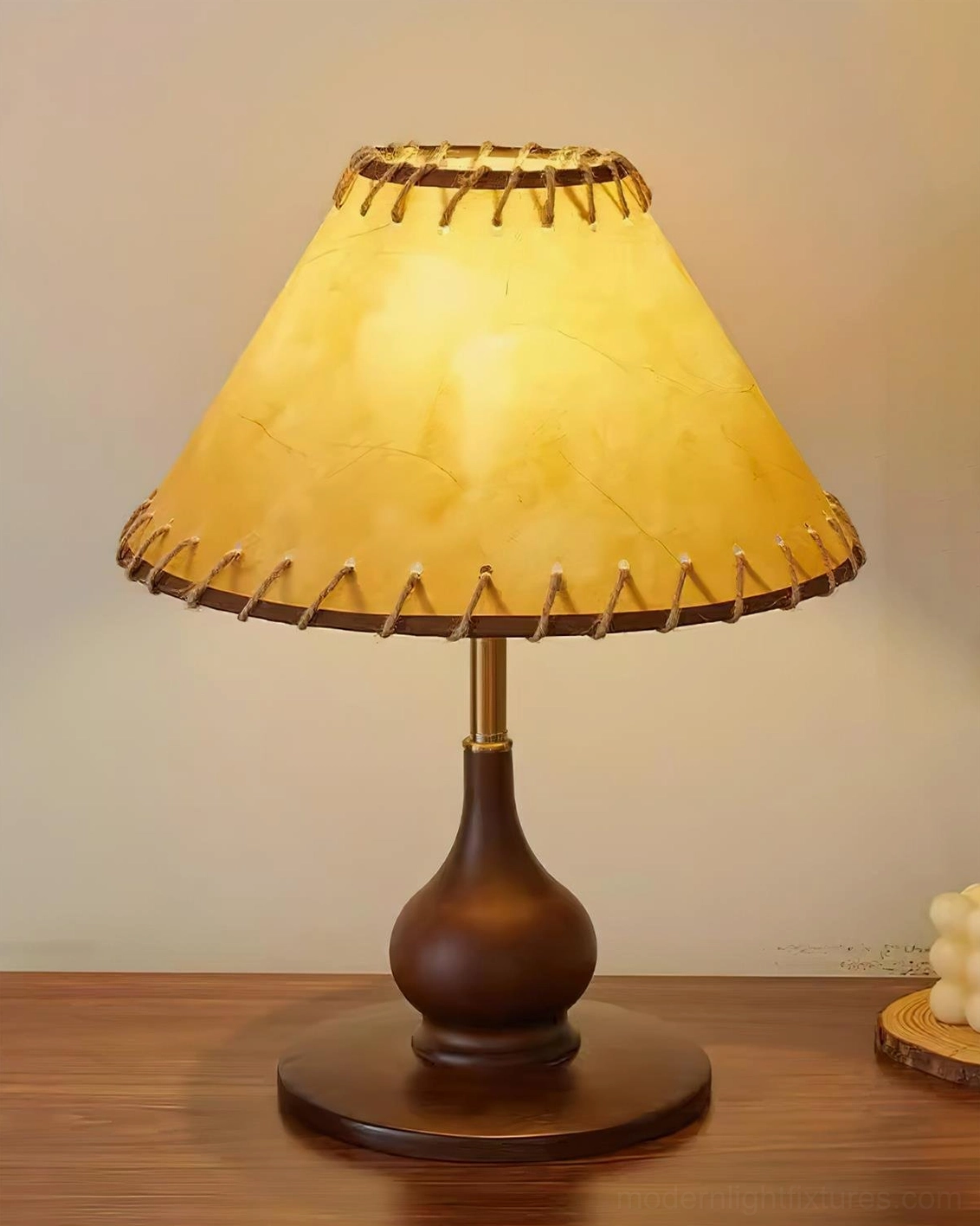 Lariat leather table lamp illuminated with warm yellow glow showing stitched shade detail