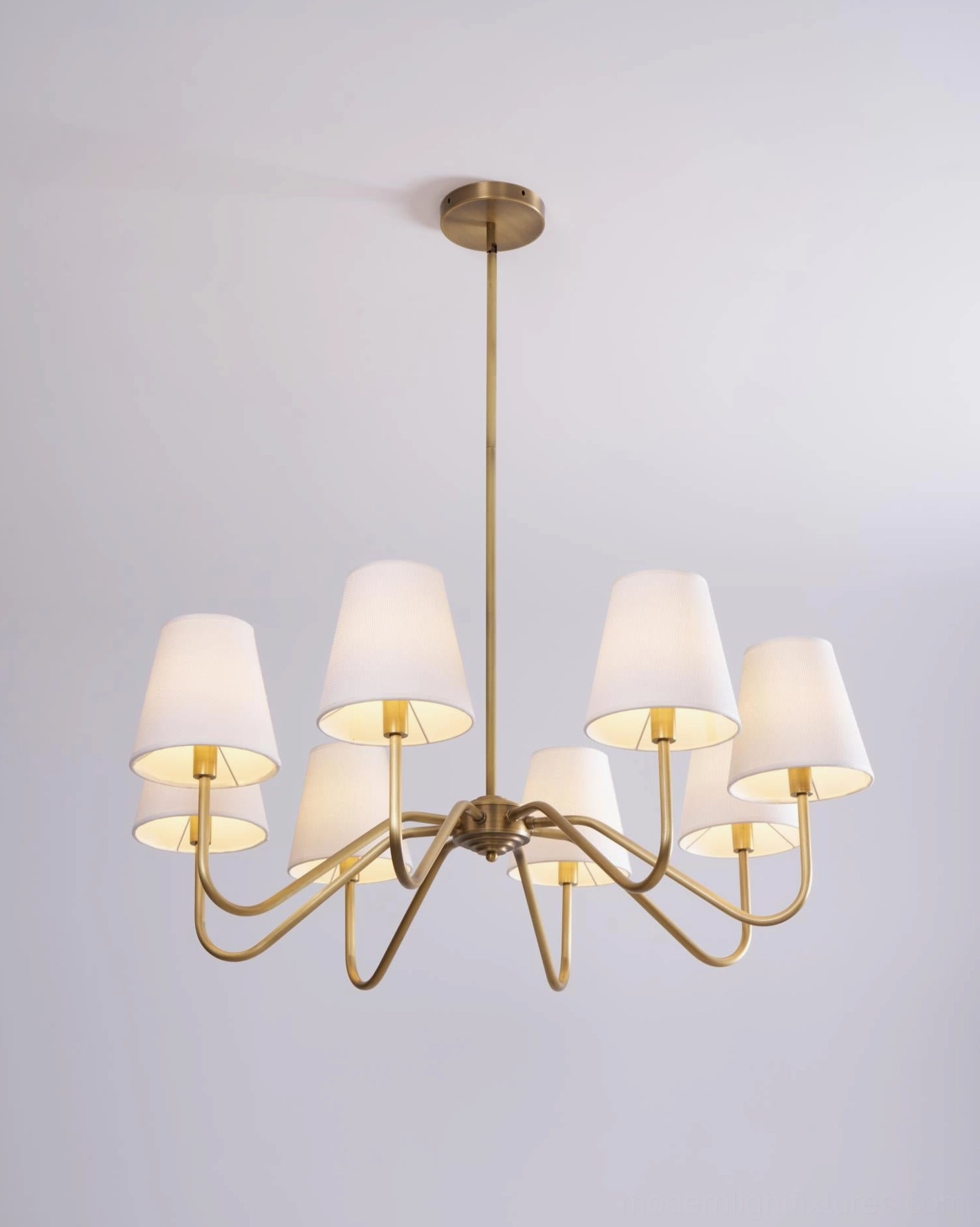 Lassen brass chandelier installation context, home interior setting, contemporary living space styling