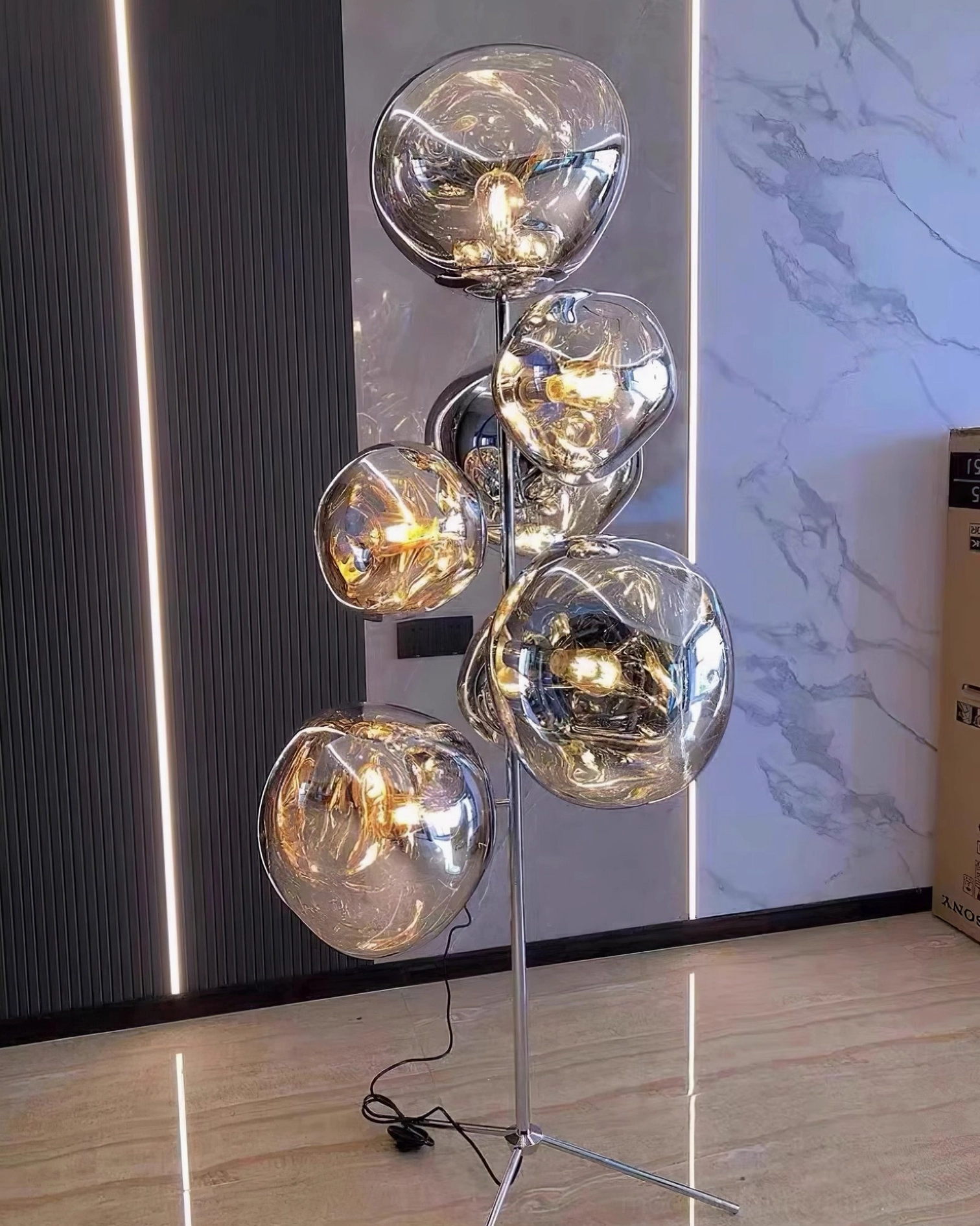Lava bubble floor lamp detail of metal tripod base and lower glass shade configuration