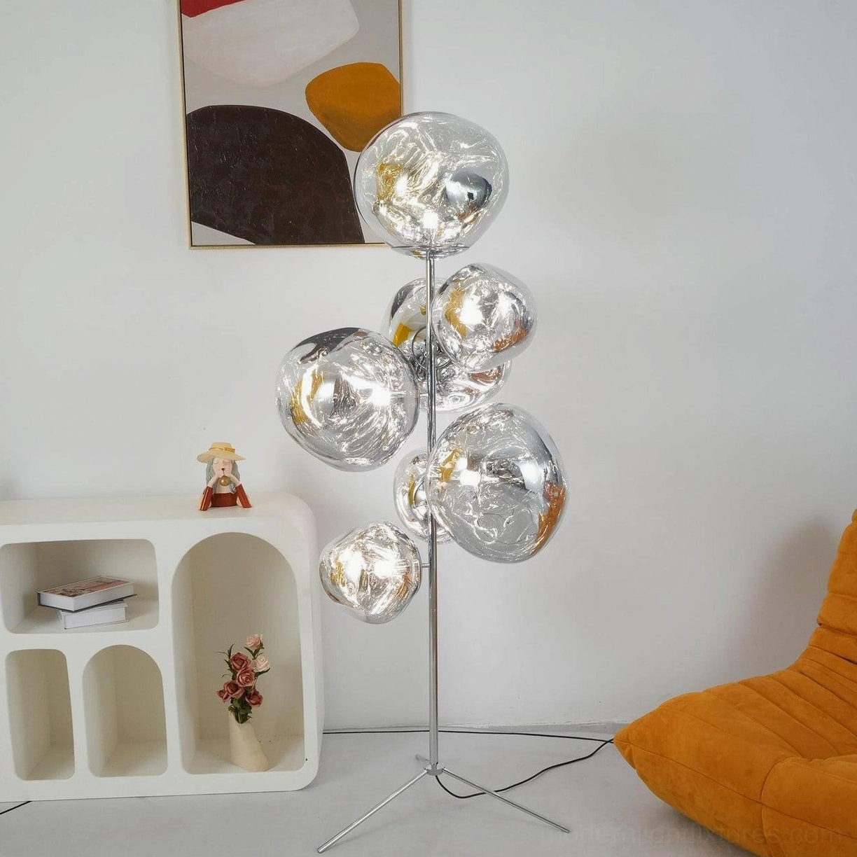 Silver mirrored bubble floor lamp in minimalist white living room with chrome metal stand