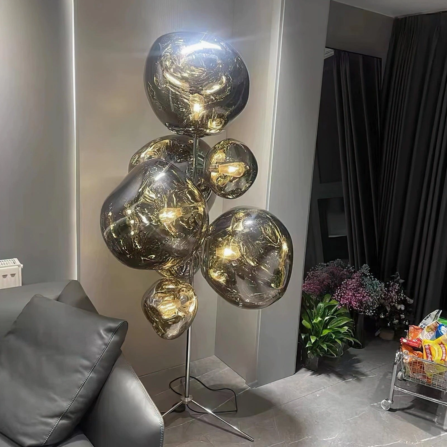 Smoke gray bubble floor lamp in dark modern living room with sofa and metallic shades