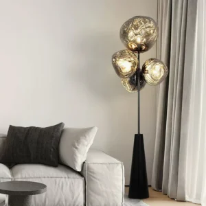 Lava glass ball floor lamp side angle in modern living room with sofa - black hardware and smoked brown glass spheres