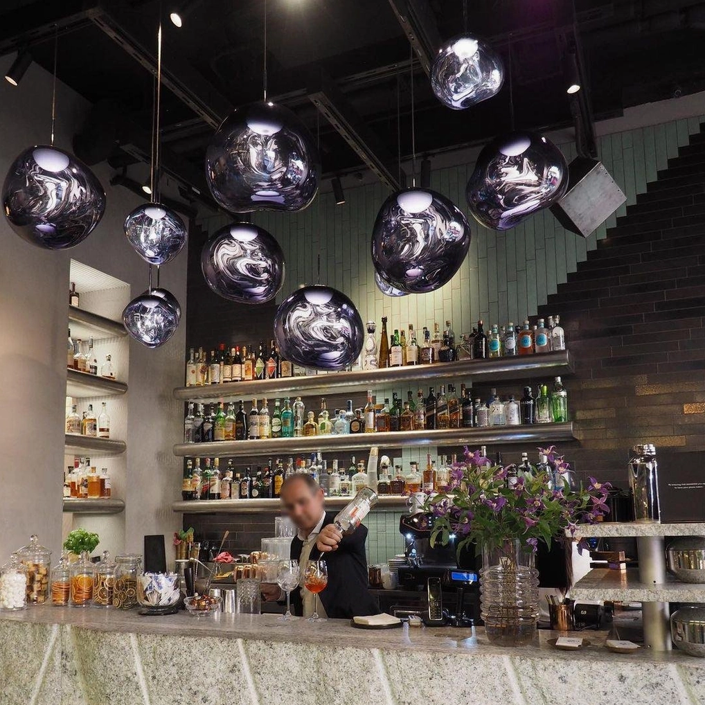 Clustered silver lava pendant lamps in modern commercial bar with polished finishes