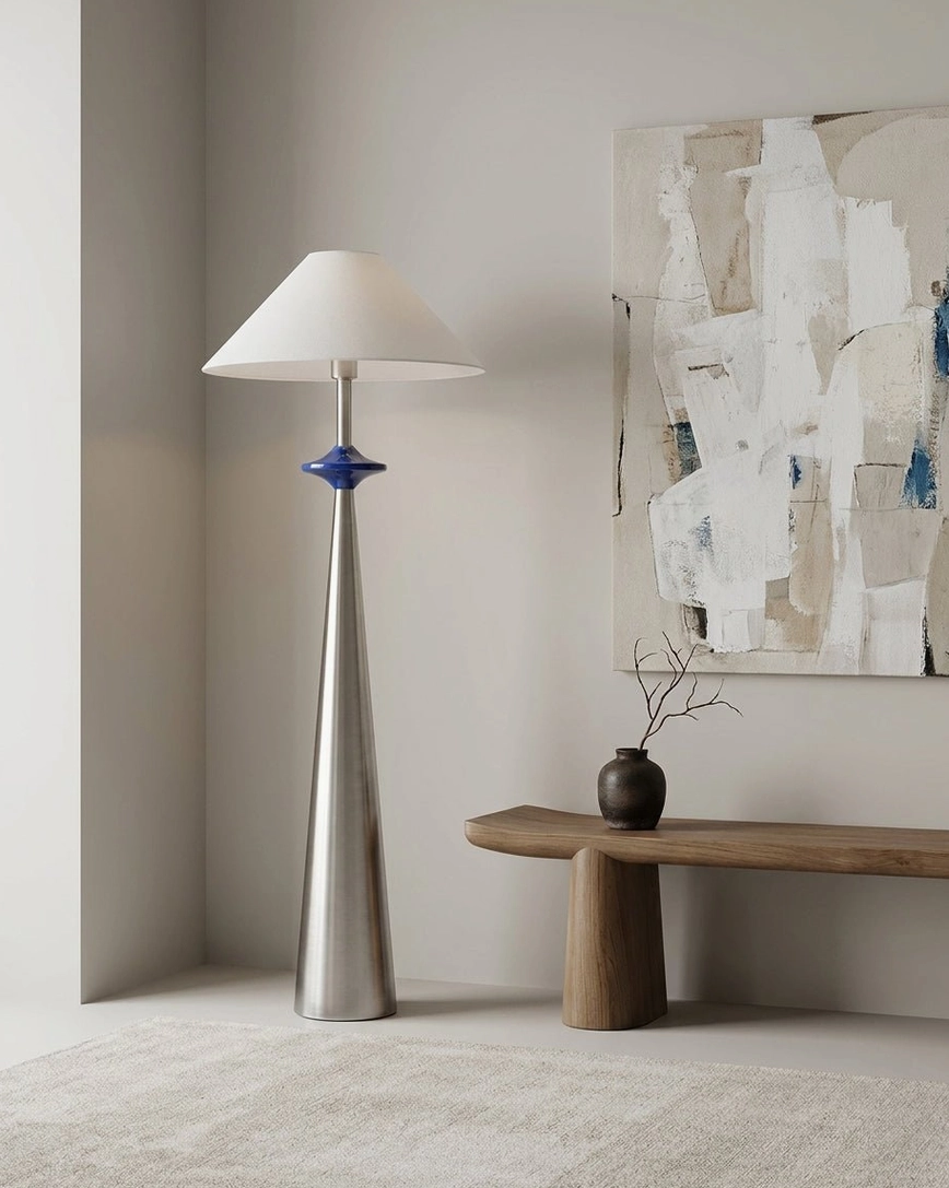 Matte stainless cone floor lamp in contemporary art gallery space with abstract wall art and minimalist decor