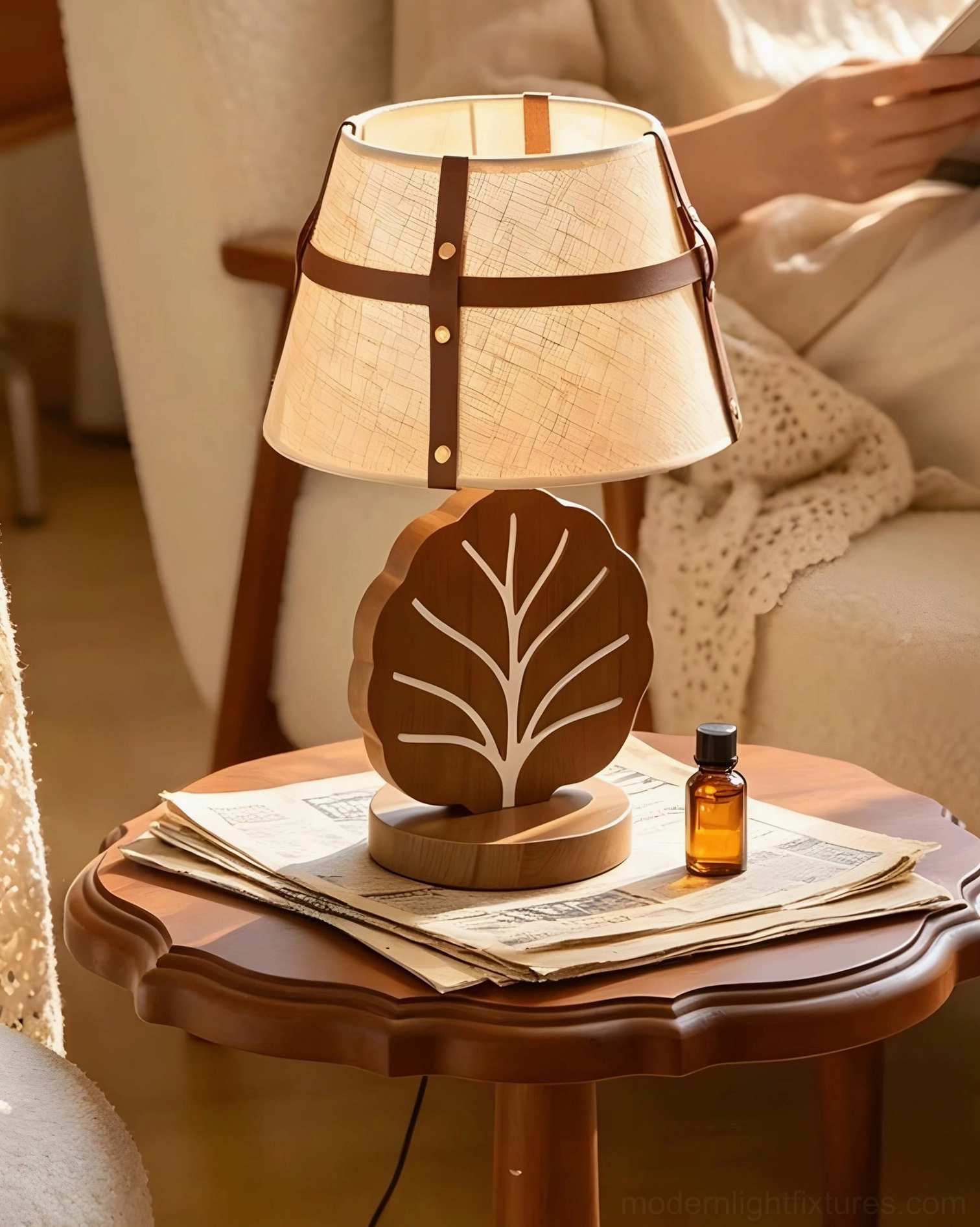 Leafora modern accent lamp beside stacked magazines and essential oil bottle with knit throw blanket, cozy bedroom reading nook styling