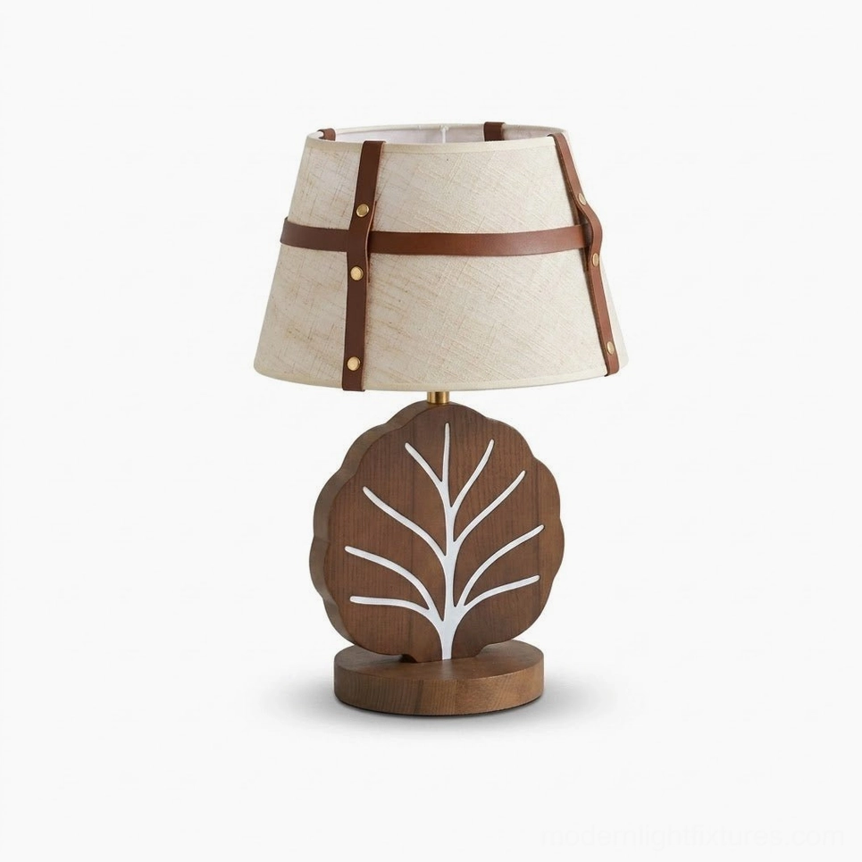 Leafora table lamp product shot - walnut wood base with white leaf vein detail, natural linen shade with leather straps and brass rivets, clean studio background