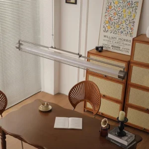 Contemporary linear pendant light above mid-century modern dining table - warm LED illumination in retro dining room