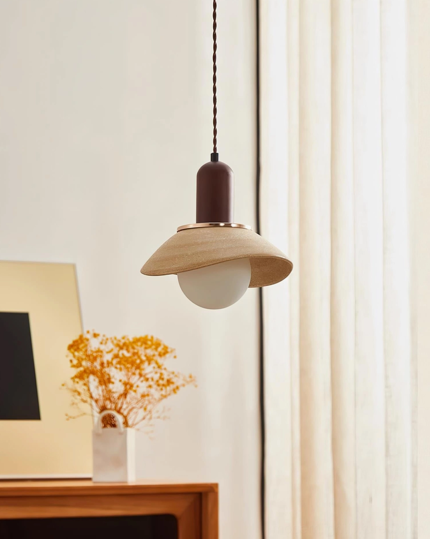 Legro pendant lamp with glowing frosted bulb installed above wooden console in contemporary home setting