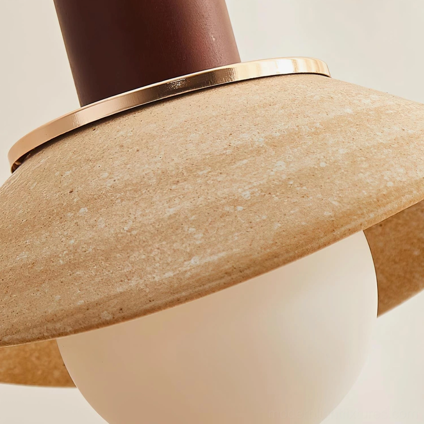 Macro close-up of Legro pendant lamp showing brass accent ring, textured ceramic surface and frosted glass bulb