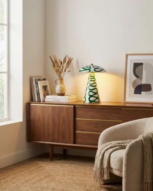 Green spiral pattern ceramic table lamp styled on mid-century modern sideboard with warm neutral decor and dried wheat ornaments