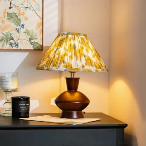 Lenora table lamp displayed on home side table with yellow floral pleated shade, interior design setting