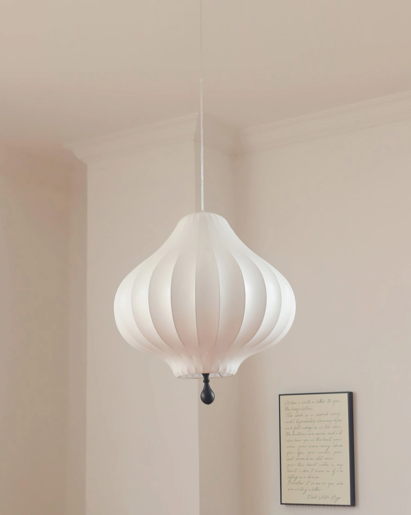 Leocadia modern pendant light in minimalist bedroom, white matte shade with black finial detail