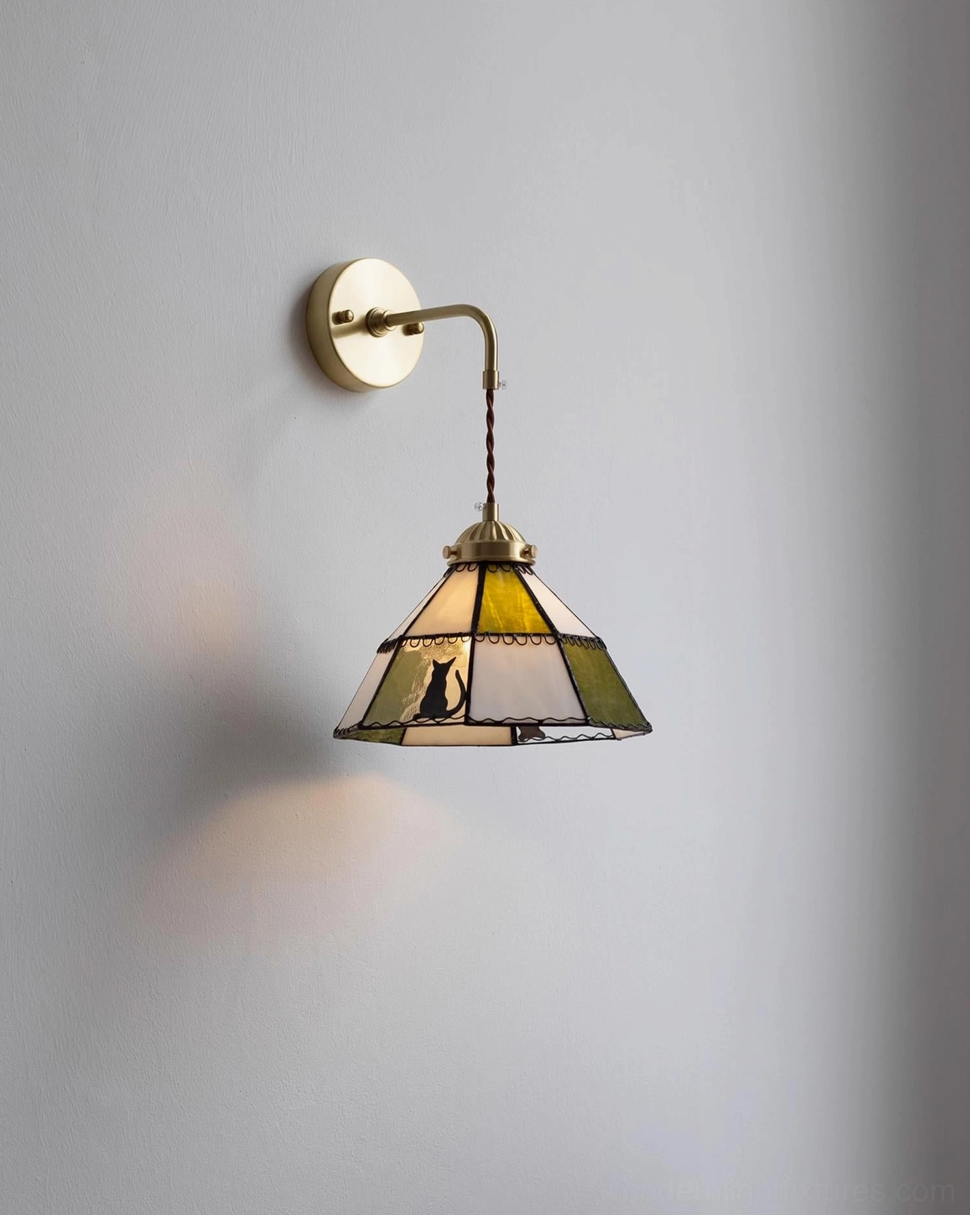 Front-right perspective of lit Leporine stained glass wall lamp with rabbit details
