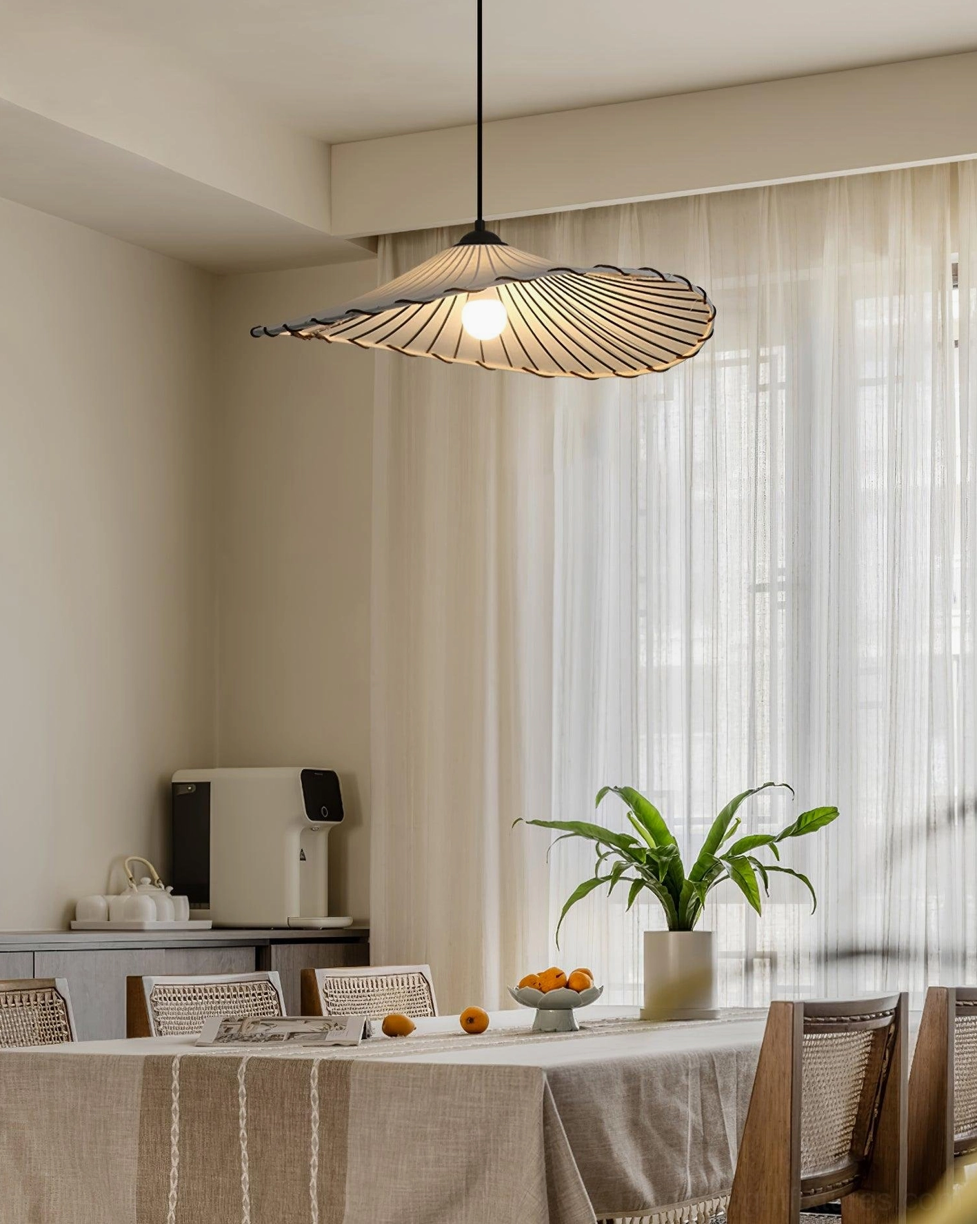 Liana pleated pendant light casting soft shadows in sunlit minimalist dining room