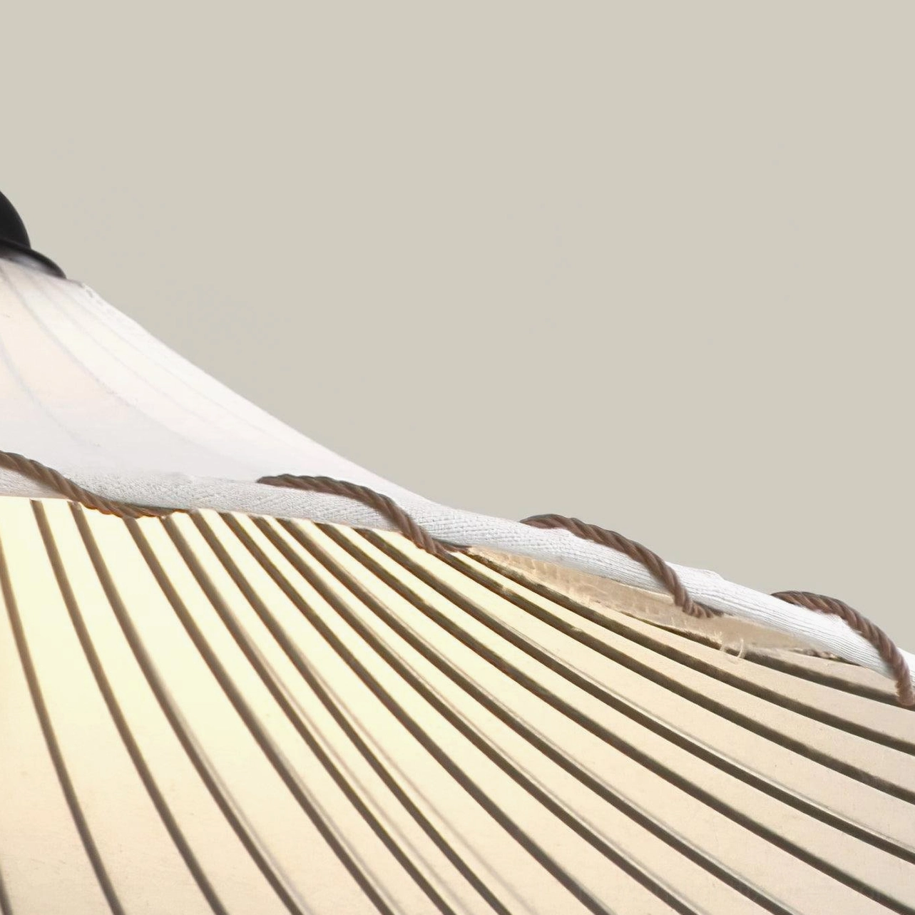 Handcrafted Liana pleated pendant lamp showing warm beige fabric and shadow interplay effect