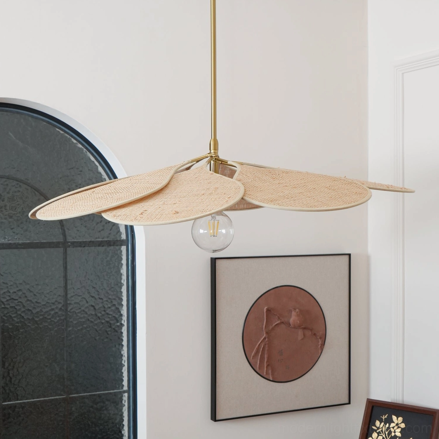 Light beige woven rattan pendant with flat petal design and gold rod, arched window setting