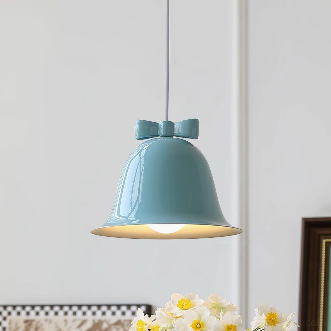 Light blue ceramic bell-shaped pendant light with matching bow ornament studio photography