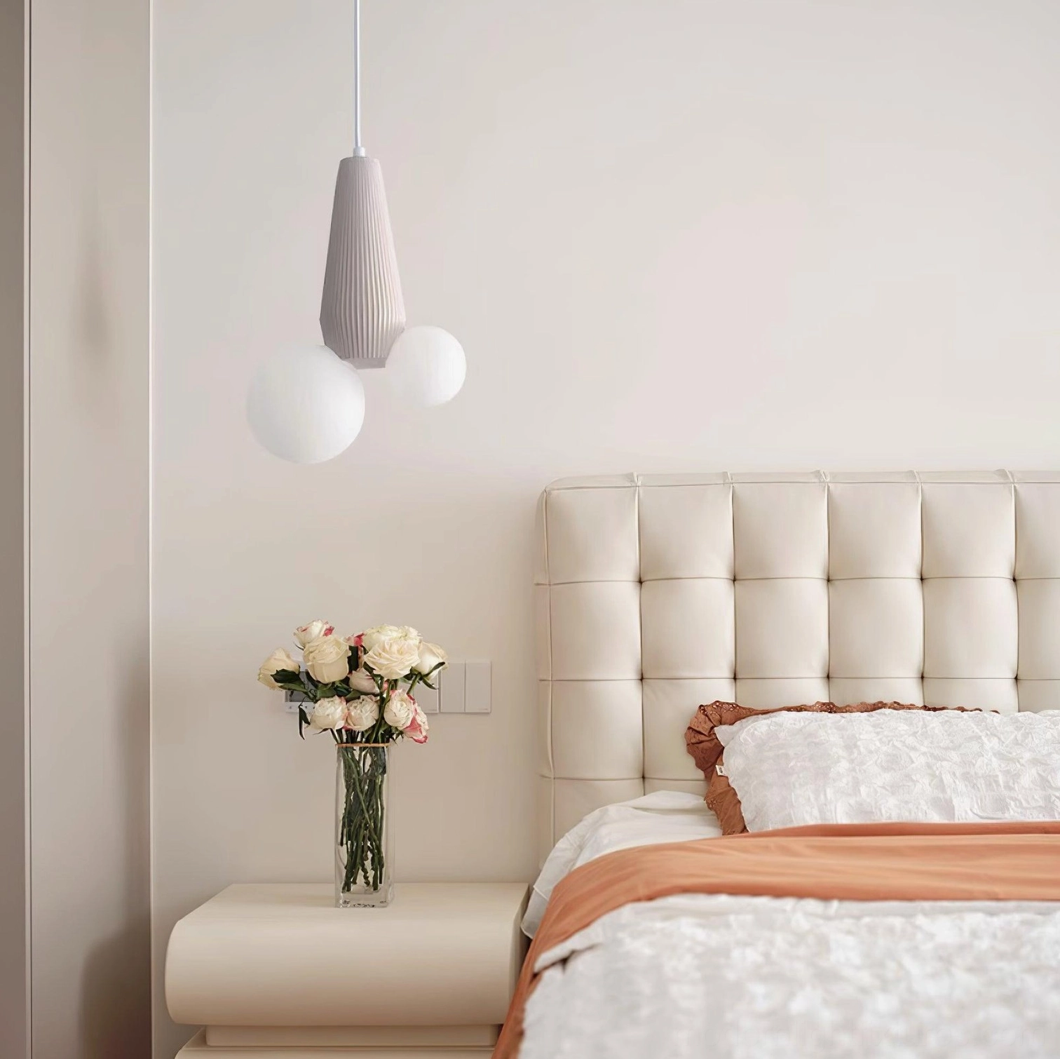 Light gray contemporary pendant fixture with differently sized frosted glass globes in master bedroom