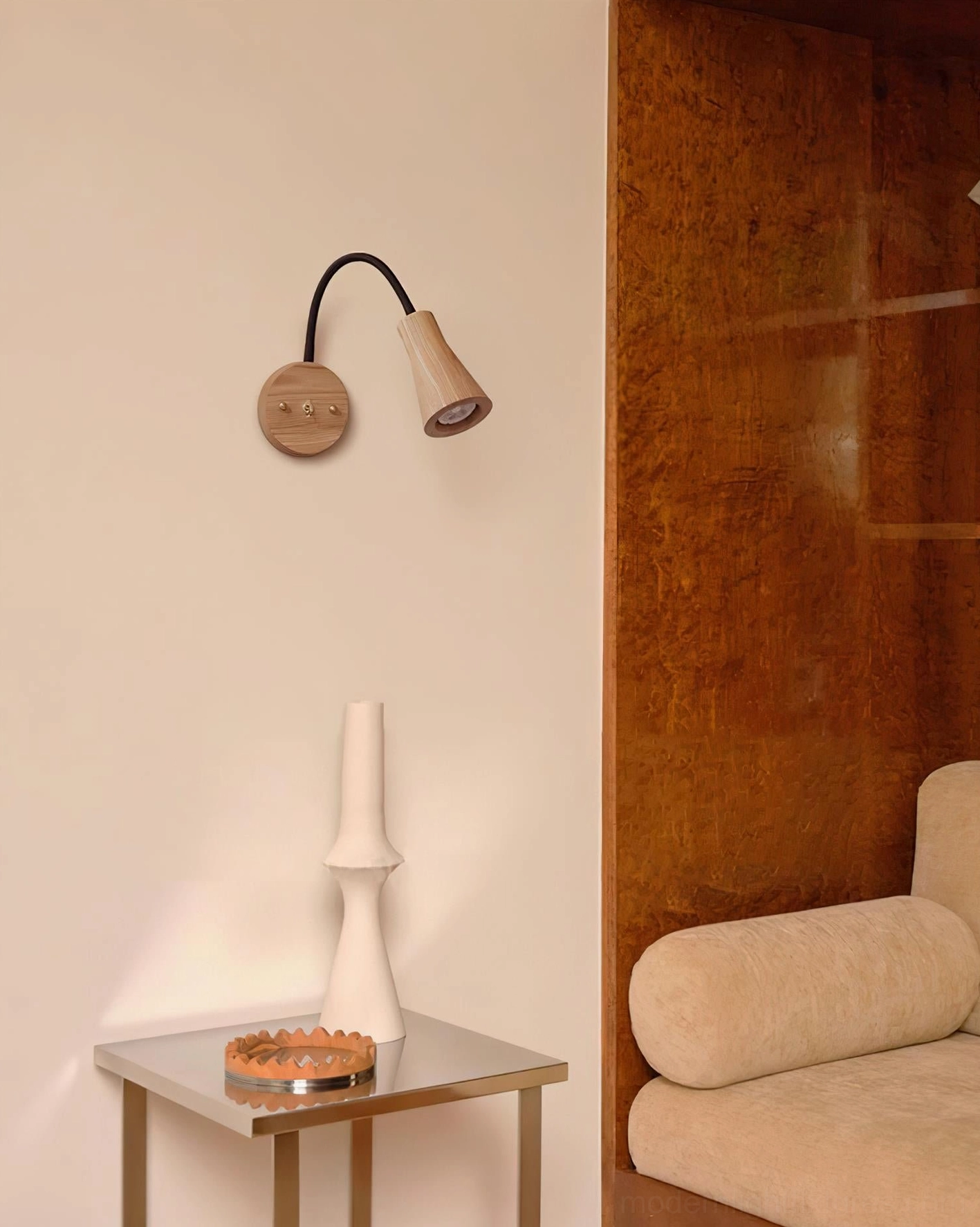 Light-toned wooden wall lamp in luxury bedroom beside table, warm ambient glow