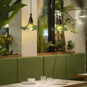Lila textured glass pendant lamp in dining room with warm ambient lighting and green booth seating