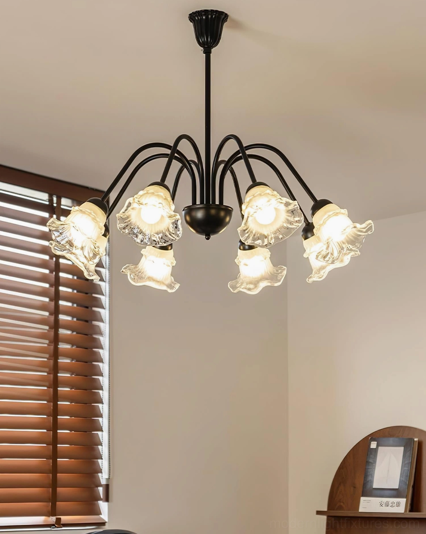 8-head Lilura botanical chandelier in residential room with wooden shutters casting warm glowing light
