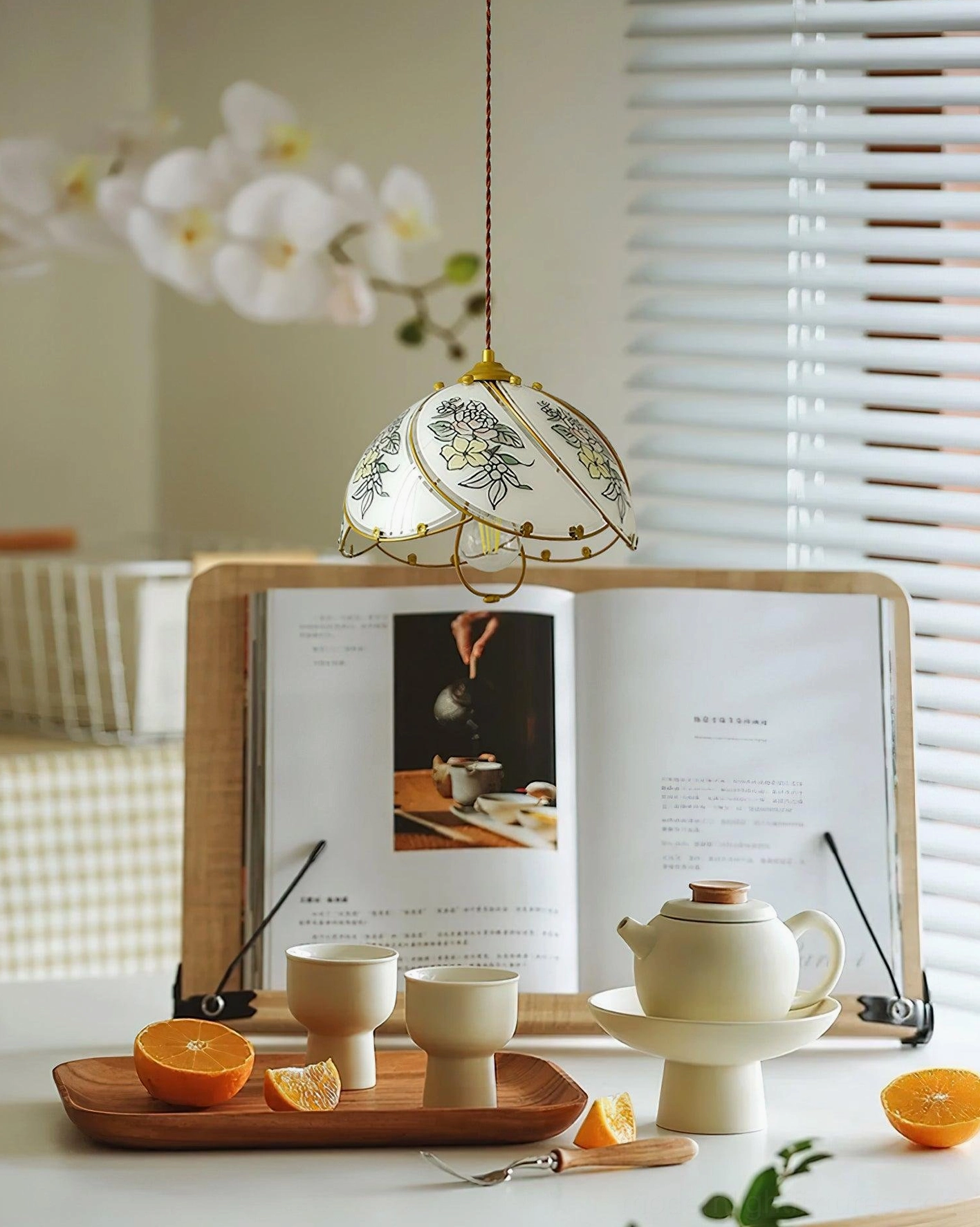Decorative lily floral pendant light paired with tea set and orchid decor on desktop display