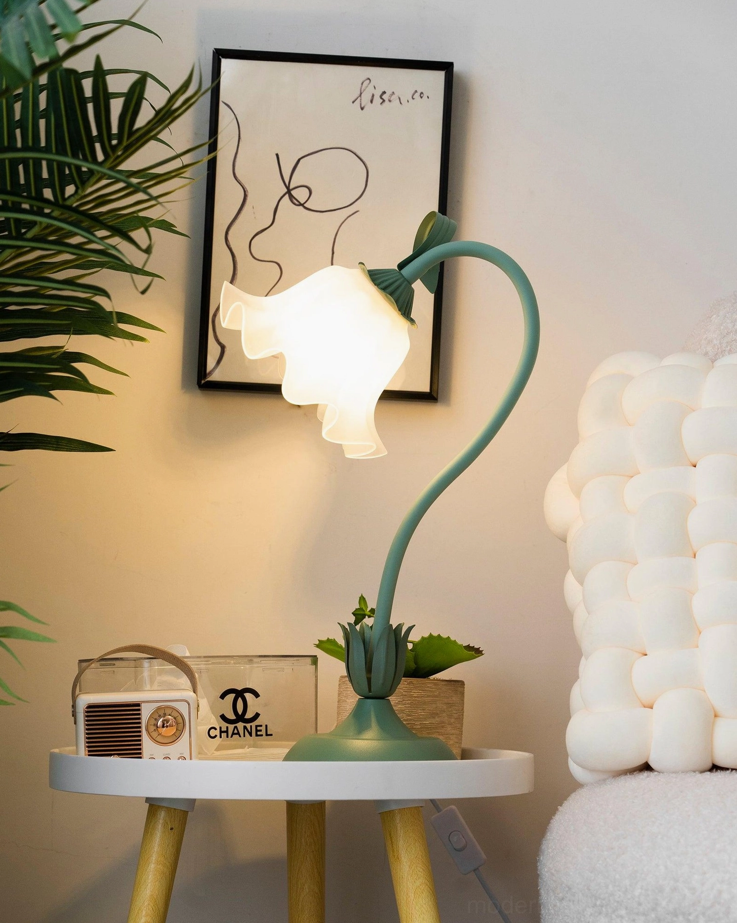 Lily flower table lamp full view showing sage green finish and frosted white shade on accent table