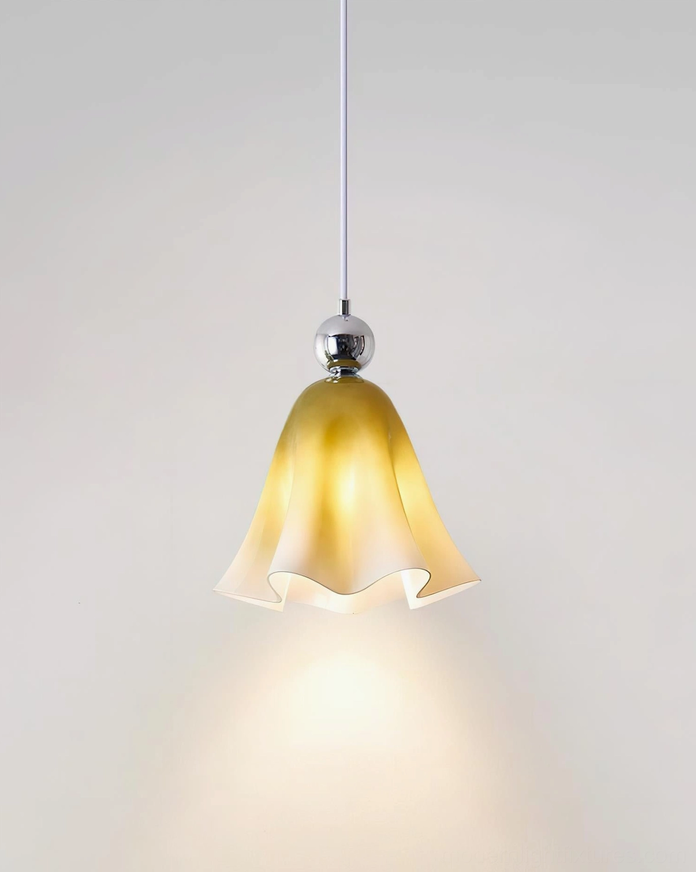 Vellia pendant light with warm yellow gradient glass shade illuminated in residential interior