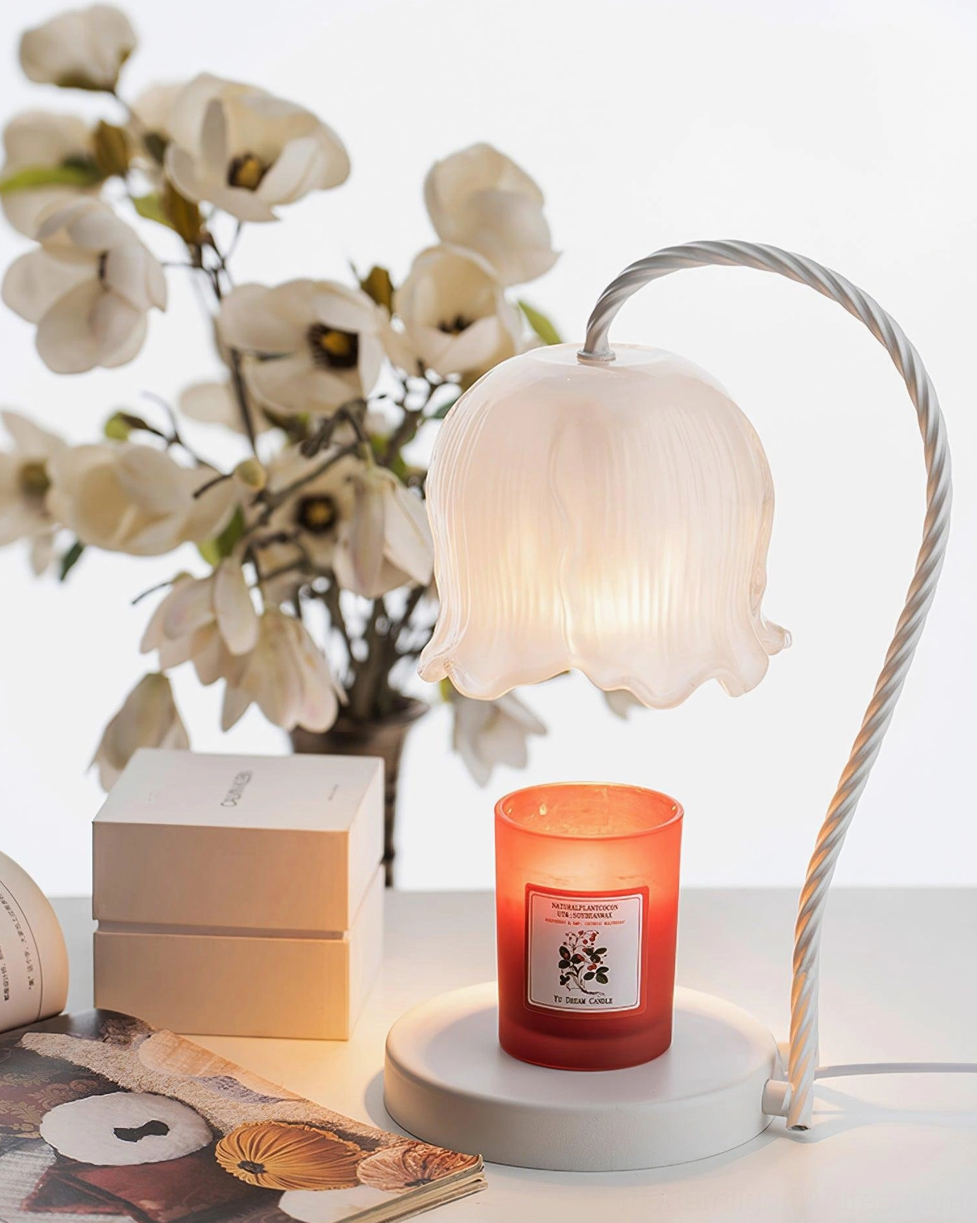 Lily of the valley candle warmer lamp displayed on home desktop with flowers and gift boxes