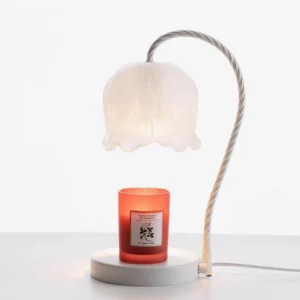 Lily of the valley candle warmer lamp with red scented candle on base, soft gray tabletop display