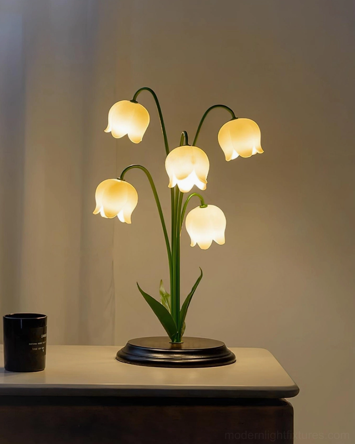 Lily of the Valley table lamp on nightstand with warm illumination and black base