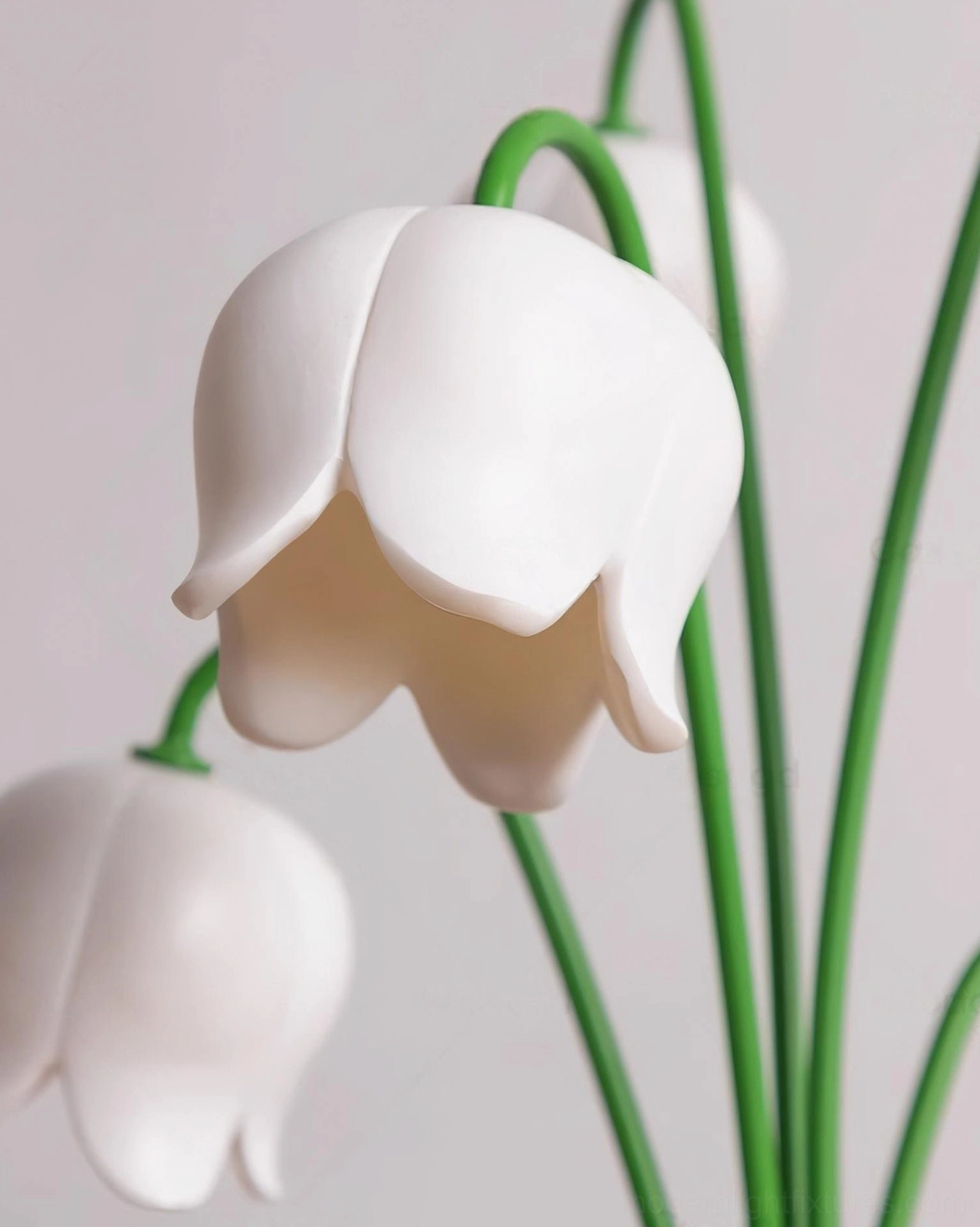 Close-up of white lily flower petals and curved green stems of modern table lamp