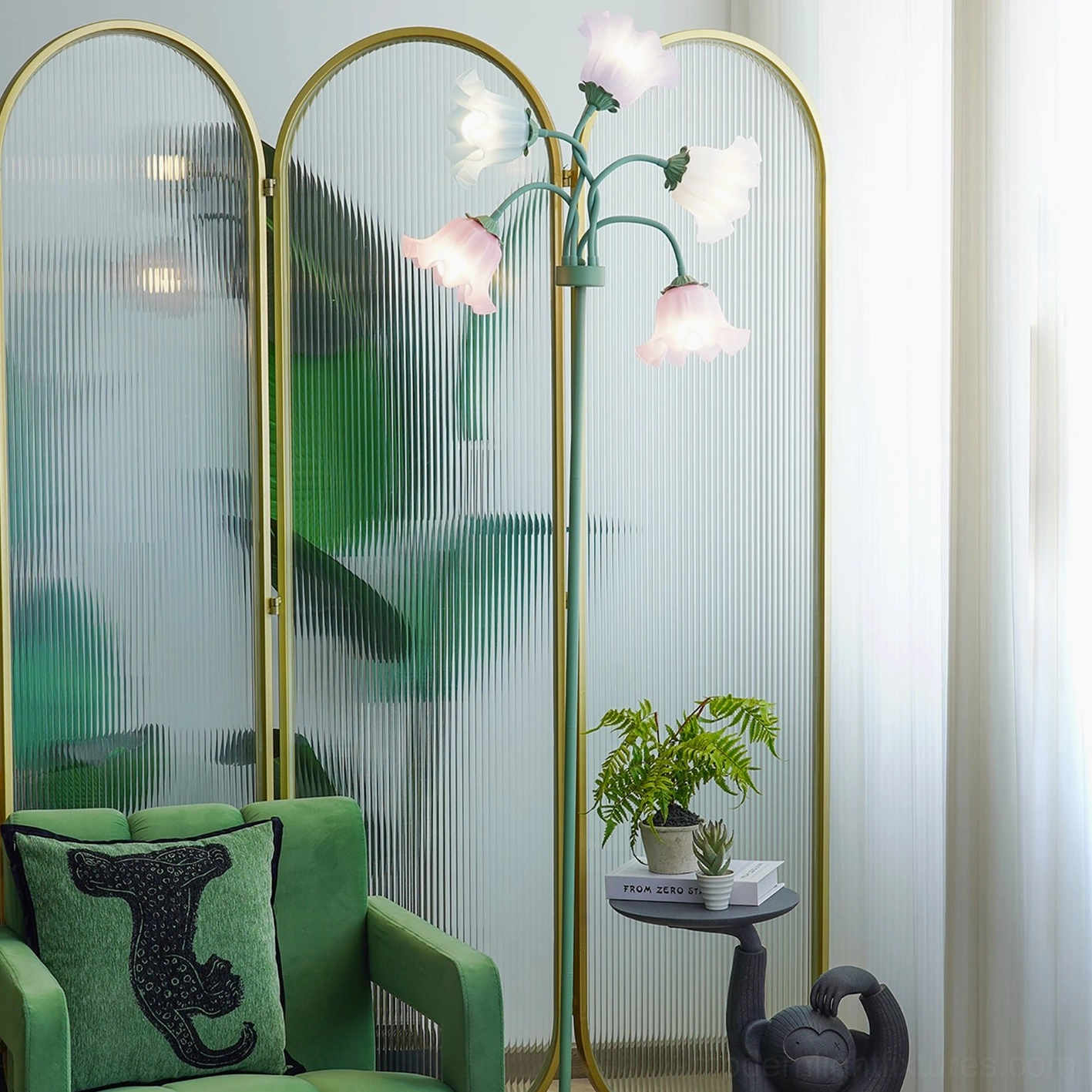 Pastel floral floor lamp with brass-green frame creating warm ambient lighting in modern living room with velvet green sofa