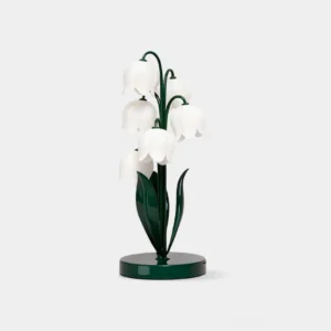 Lily of the valley table lamp with white frosted acrylic petal shades and dark green metal frame, front studio view with minimalist aesthetic