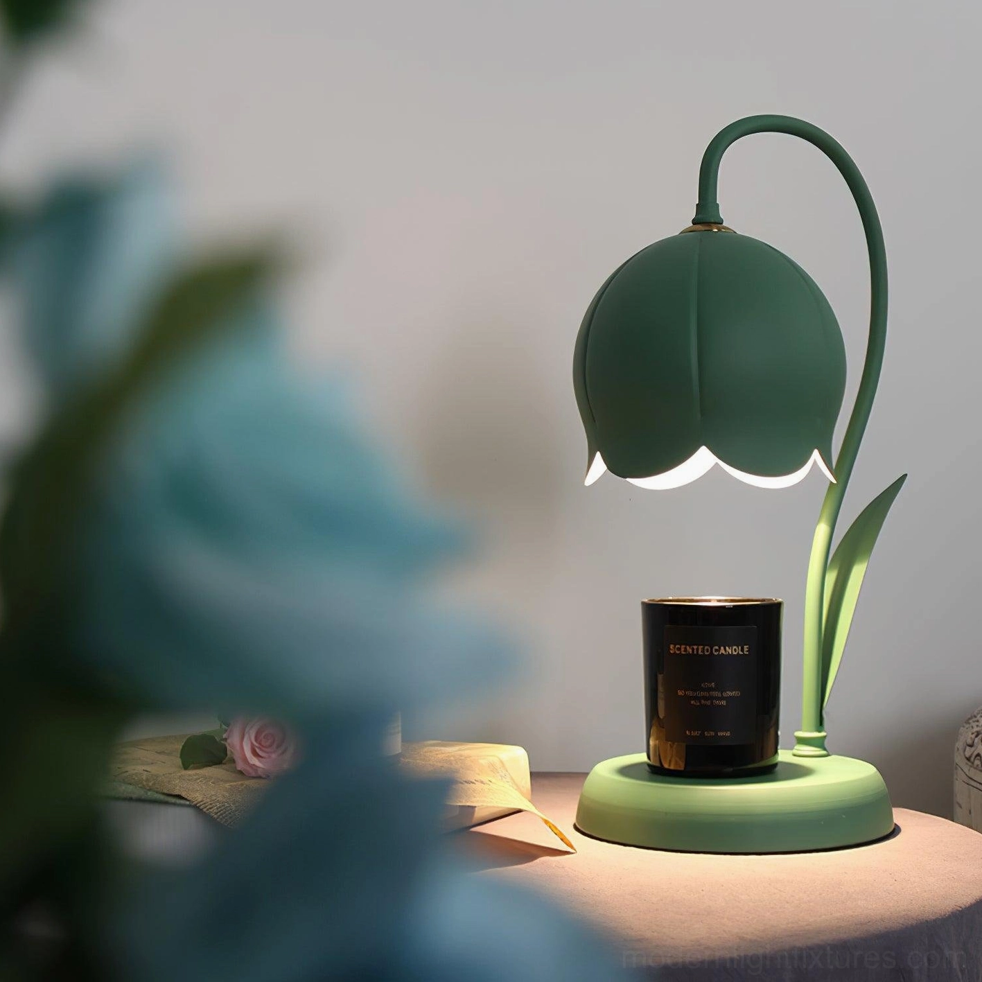 Dark green lily wax melting lamp close-up angle with scented candle, blurred floral foreground styling