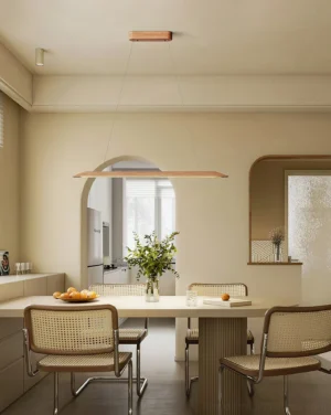 Modern linear wood pendant light hanging above dining table in Scandinavian Nordic interior design