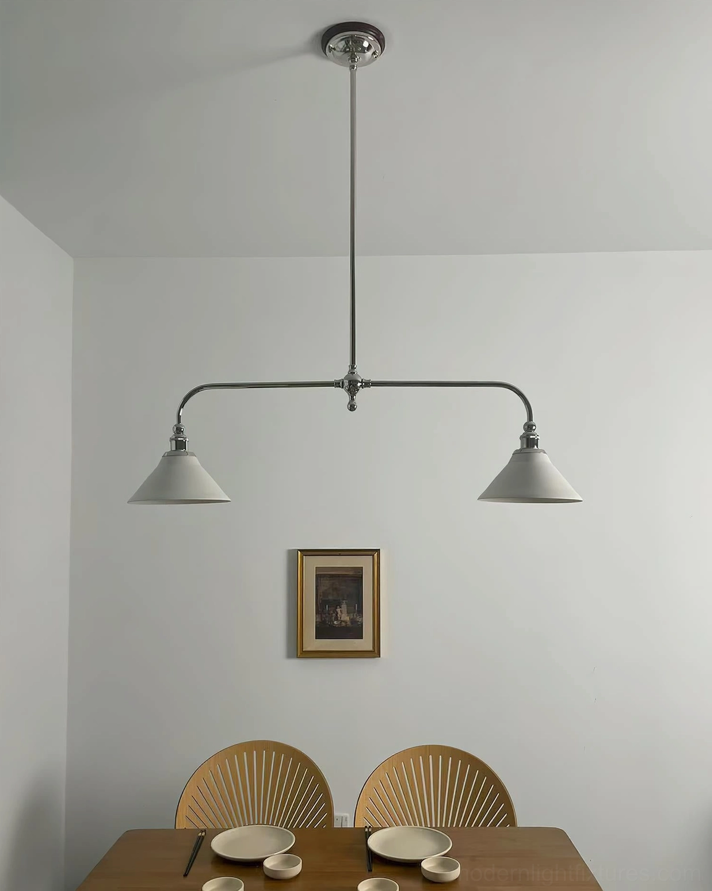 Linear brass pendant fixture with white ceramic conical shades suspended in elegant transitional interior setting