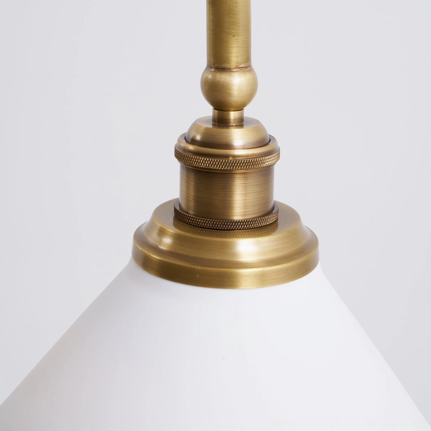 Linear chandelier with symmetric brass frame and two white ceramic conical shades bridging classic and modern design