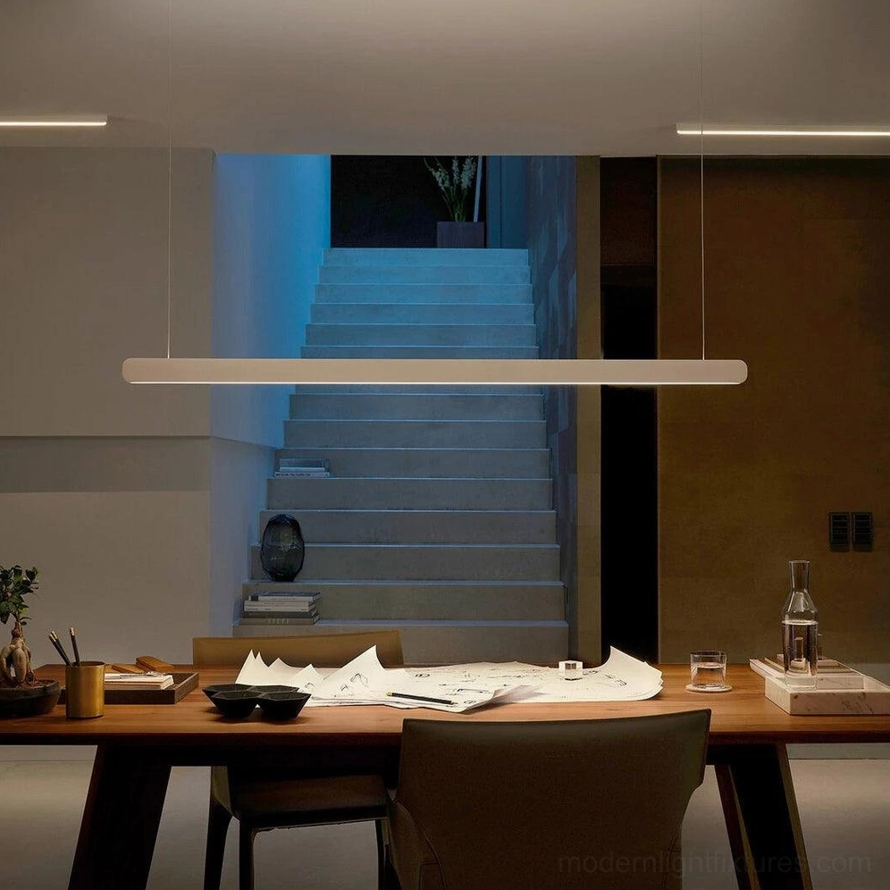 Sleek linear pendant light fixtures illuminating modern dining and stairwell area
