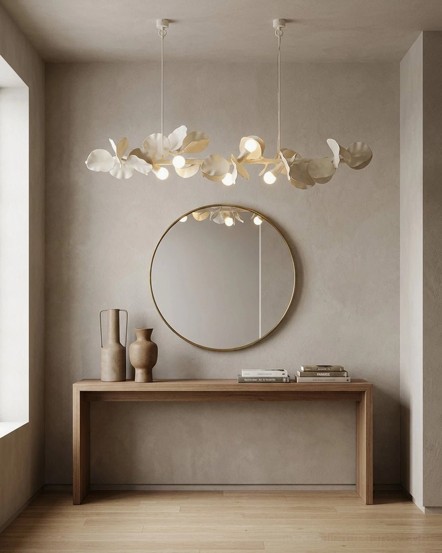 Contemporary linear chandelier above console table with round mirror in modern minimalist dining nook