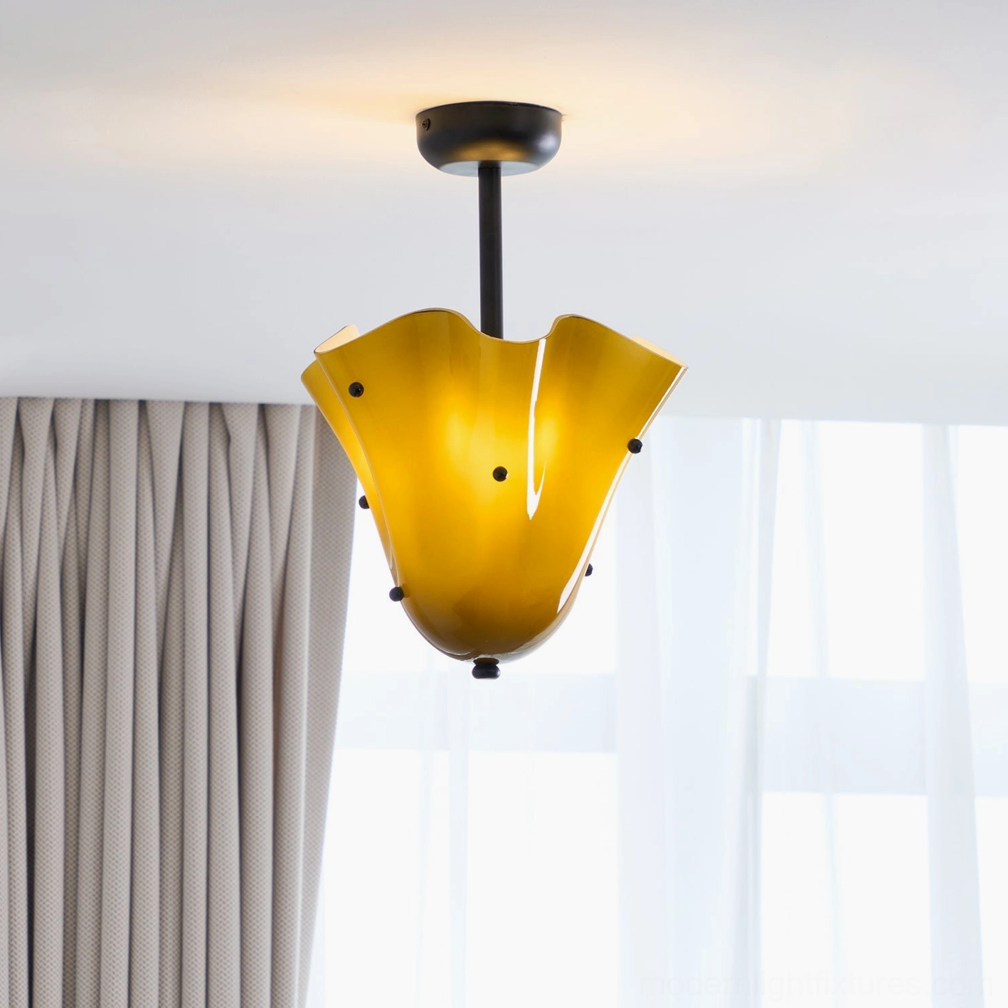 Illuminated amber yellow vera ceiling fixture in bedroom setting with soft warm glow