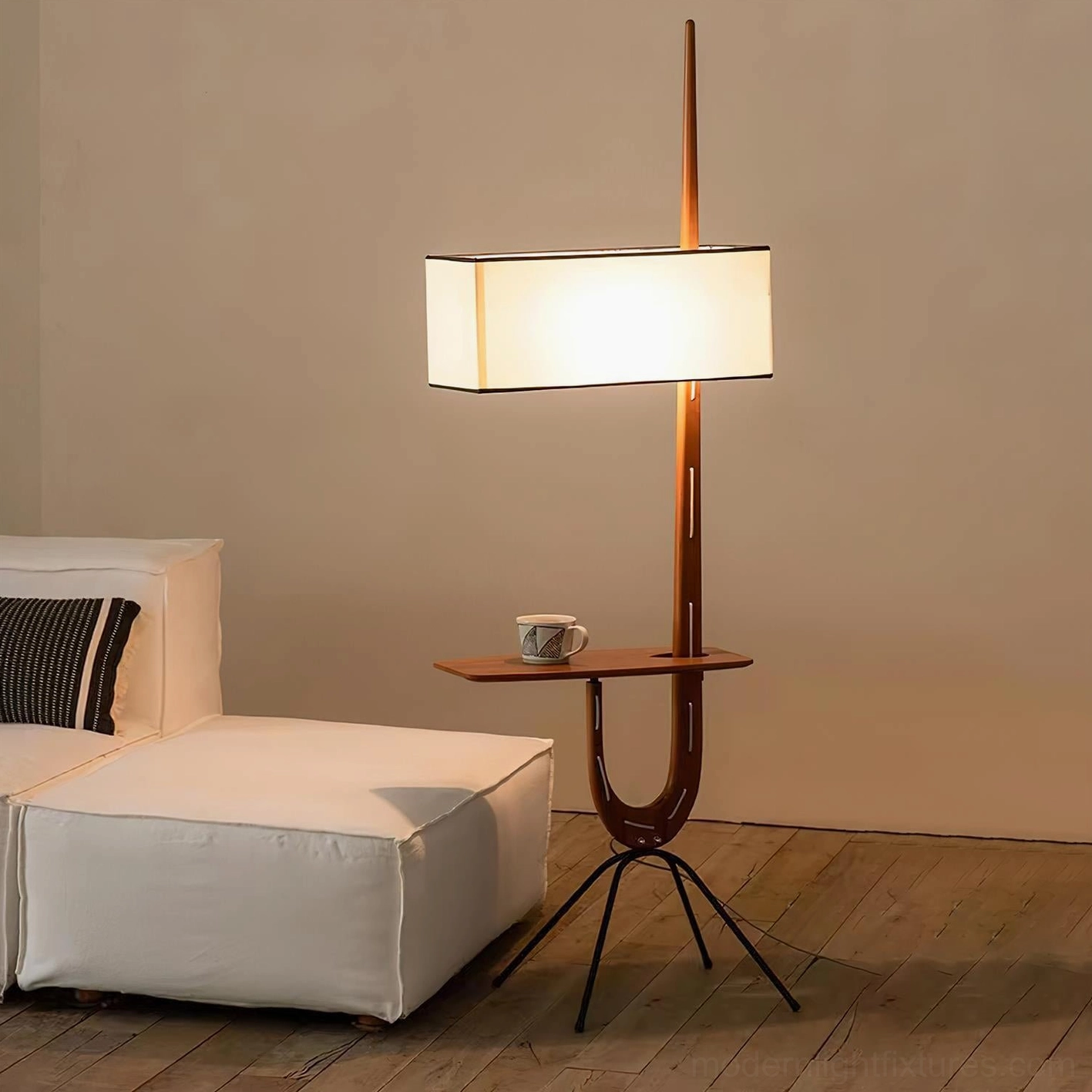 Illuminated modern floor lamp with side shelf holding tea cup in bedroom setting, eye-level view