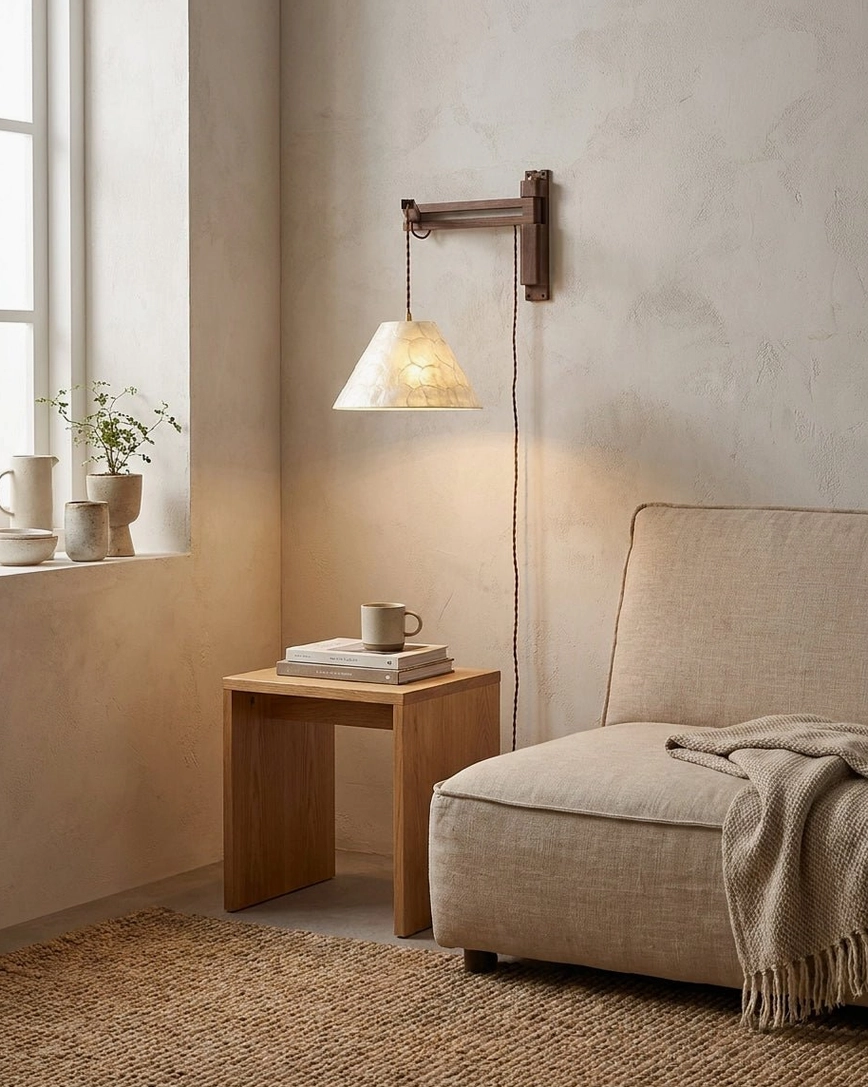 Swing-arm wall sconce mounted beside lounge chair in neutral living room interior, accent lighting