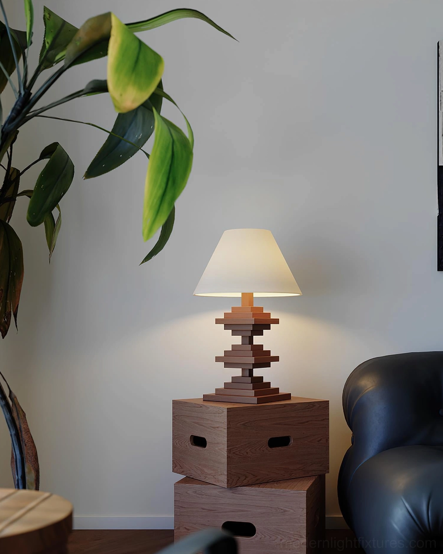 Sculptural wooden tower table lamp in living room lounge scene with leather sofa green plant and wooden furniture styling