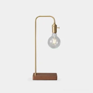 Lola modern brass table lamp with exposed Edison bulb and walnut wood base on white background, front view